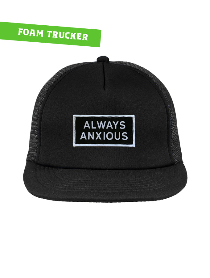 &quot;Always Anxious&quot; in white block text embroidered on black patch with white merrowed edge on a flat brim foam snap back.  Art by Print Ritual.